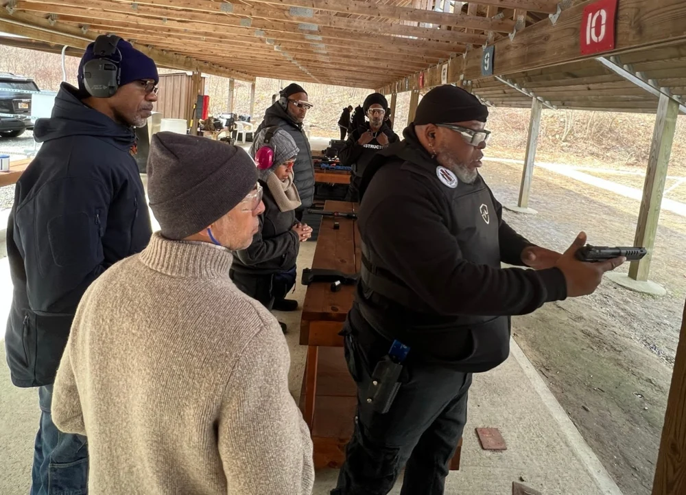 Damon Wright teaching a group at an outdoor shooting range